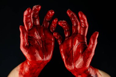 Siyah bir arka planda kanlı kadın elleri