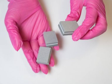 Elinde tırnak törpüleri tutan pembe eldivenli manikürcü.