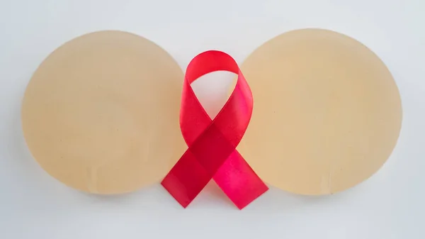 Breast implants and satin ribbon. Breast cancer awareness symbol