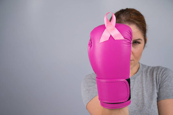 Woman doctor in pink boxing gloves on a white background