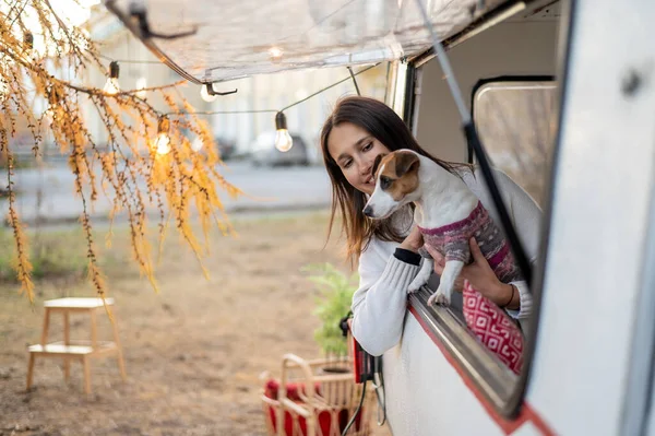 Biała Kobieta Wygląda Przez Okno Furgonetki Przytulając Swojego Psa Jacka — Zdjęcie stockowe