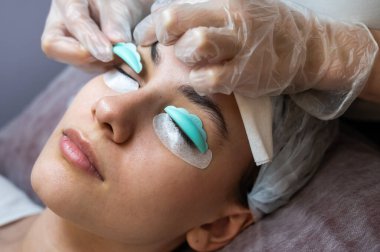 Sahip, müşteriye kirpikleri kaplamak için özel bir silindir takar