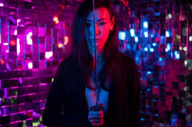 Erkek transseksüel neon ışık stüdyosu. Samuray kılıçlı Asyalı