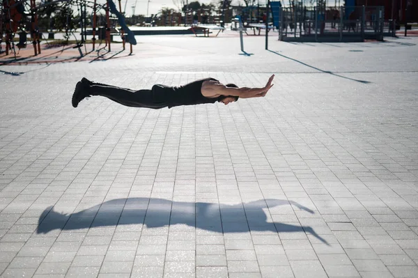Een Man Zwarte Sportkleding Springt Met Push Ups Het Park — Stockfoto