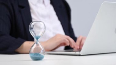 Kum saatinin süresi doldu. İş kadını laptopunu kapatır ve gider.