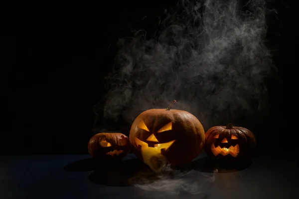 Pumpar Med Snidade Grimaser Och Ljus Inne Mörkret För Halloween — Stockfoto