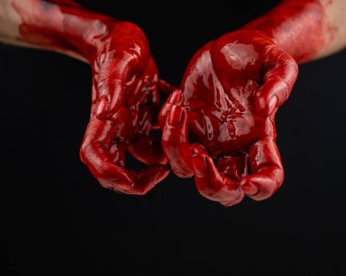 Siyah bir arka planda kanlı kadın elleri