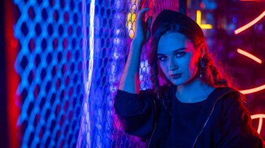 Beyaz kadın neon stüdyoda poz veriyor.