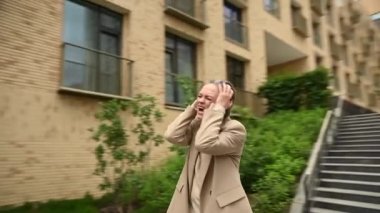 Yaşlı gri saçlı iş kadını bir hata yaptı ve ellerini açık havada tutuyor. Video 360 derece