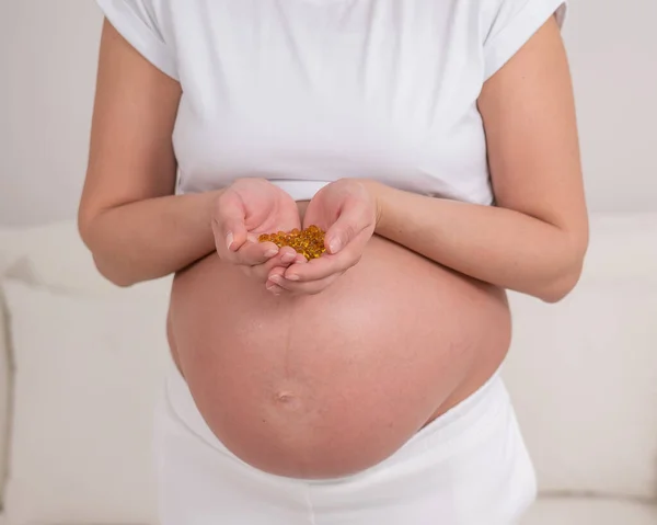 Těhotná Žena Nahým Břichem Drží Plnou Hrst Vitamínů Průhledné Zlaté — Stock fotografie