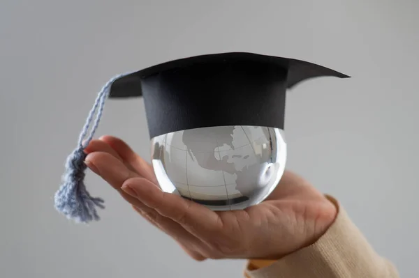 Woman Holding Crystal Globe Wearing Graduation Cap — Stock Photo, Image