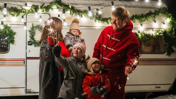 Happy parents with three sons celebrating christmas in motorhome