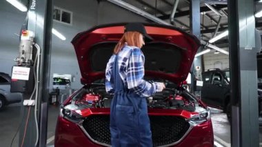 Kafkas kadın oto tamircisi hataları teşhis etmek için özel bir bilgisayar kullanıyor.