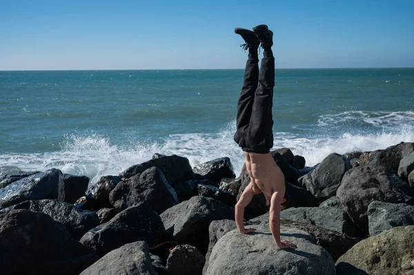 Shirless Man Doet Handstand Rotsen Bij Zee — Stockfoto
