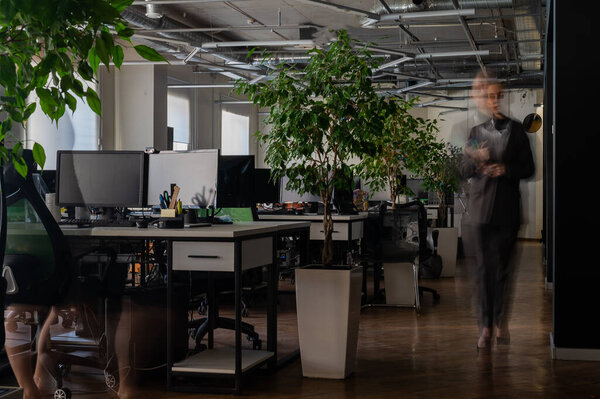 Blurred female figure in motion in the office