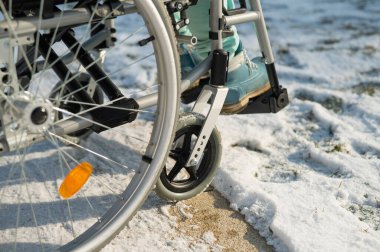 Kışın açık havada tekerlekli sandalyedeki kadın bacakları.