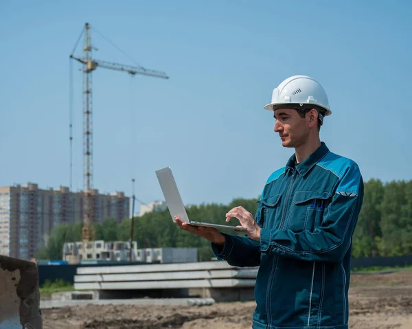 Constructor Masculino Casco Levanta Contra Fondo Una Obra Construcción Con —  Fotos de Stock