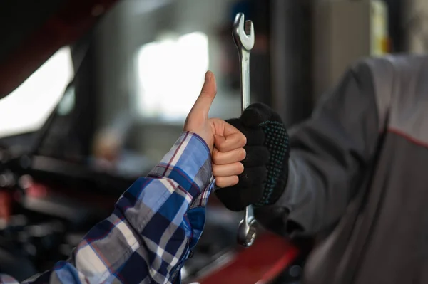 女性的近视手指头向上 机械师与工具手牵手 在完成工作后 戴手套的汽车主人表现出积极的姿态 — 图库照片