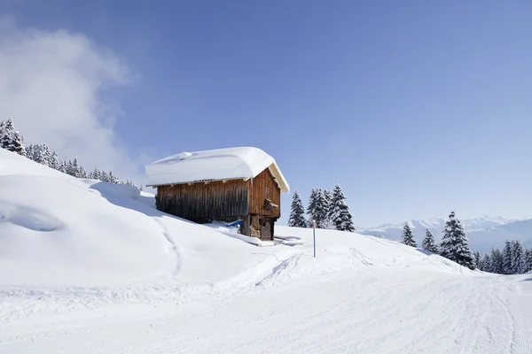 Beautiful brightly lit scenic view of mountain slope with a hut. — Stock Photo, Image