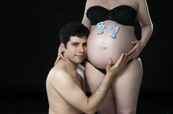 Mladý otec poslouchá břichem baby. — Stock fotografie