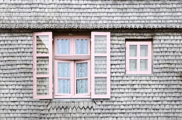 Beautiful pink windows on the facade of a wooden House — Stock Photo, Image