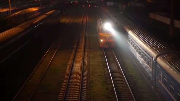 The train travels at night on the rails towards the camera. Top view — Stock Video