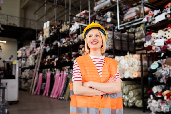 Portrait of confident factory woman in arms crossed smiling to camera. Female worker working for logistic business shipping and delivery service. copy space