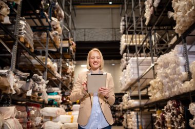 Dijital tabletle çalışan kadın işçiler Lojistik İthalat ve ihracat malzemeleri paketlerini Depoya, Lojistik Konseptine işaretliyor
