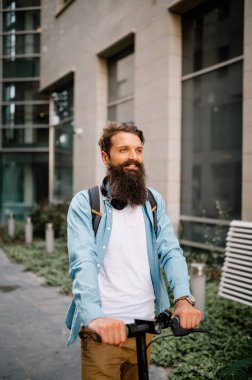 portrait of a young businessman returning from work, uses an electric scooter to transport