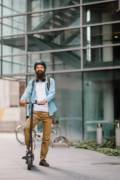 Young business man in a riding an electric scooter on a business meeting, office buildings, scooter, businessman