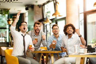 Arkadaşlar tezahürat yapıyor. Dört mutlu futbol taraftarı barda bira içiyor.