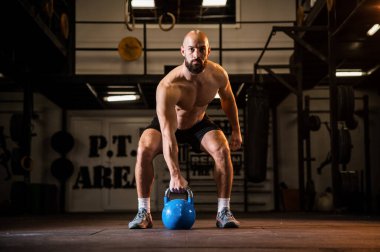 Spor giyim sektöründe formda genç bir adam spor salonunda bir halteri kaldırmaya odaklanmıştı.