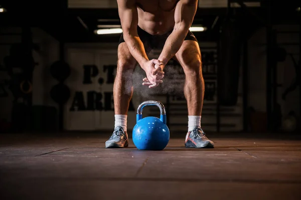 Weightlifter clapping hands and preparing for workout at a gym.