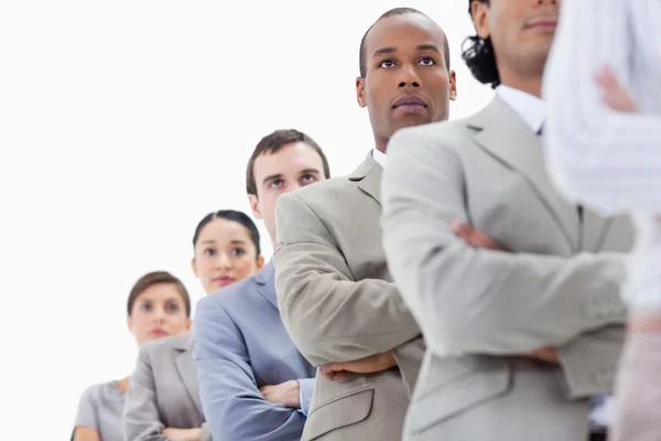 Low-angle shot of a serious business team crossing their arms in — Stock Photo, Image