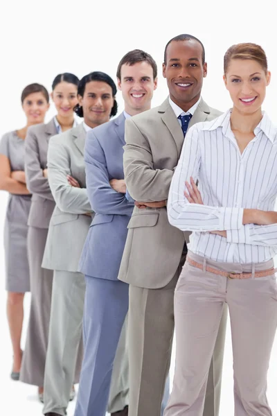 Smiling workmates dressed in suits crossing their arms in a sing — Stock Photo, Image