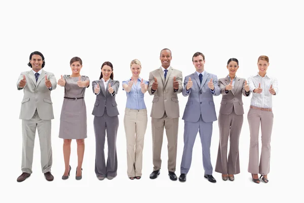 Sorridente team di lavoro fianco a fianco con i pollici in su — Foto Stock