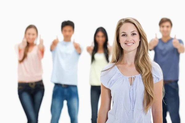 Nahaufnahme einer lächelnden Frau mit zustimmendem Blick hinter sich — Stockfoto