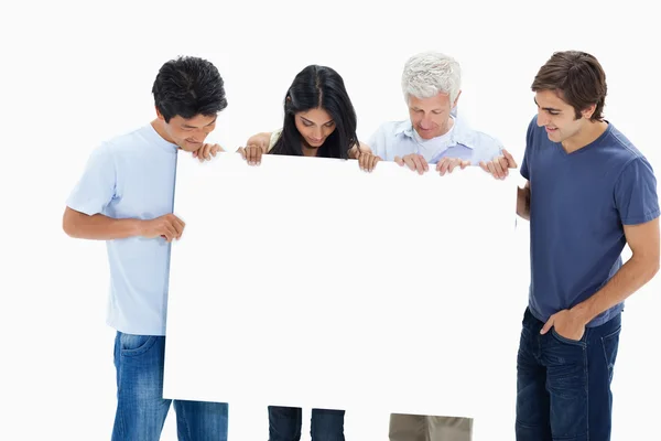 In jeans holding and watching a big sign — Stock Photo, Image