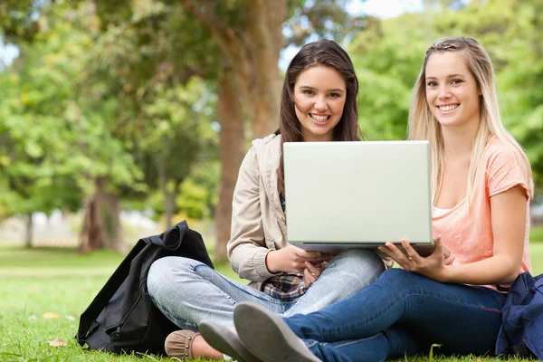 Usmívající se teenageři sedí při používání notebooku — Stock fotografie
