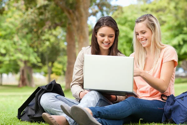 Skrattande tonåringar sitter när du använder en bärbar dator — Stockfoto