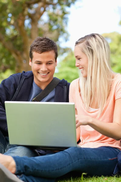 Close-up van jonge lachen zittend met een laptop — Stockfoto