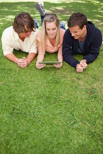 Drie jonge met behulp van een tactiele tablet — Stockfoto