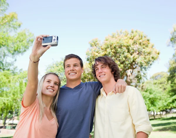 Primer plano de tres estudiantes sonrientes tomando fotos de sí mismos — Foto de Stock