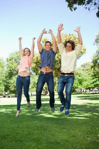 Tres estudiantes saltando — Foto de Stock