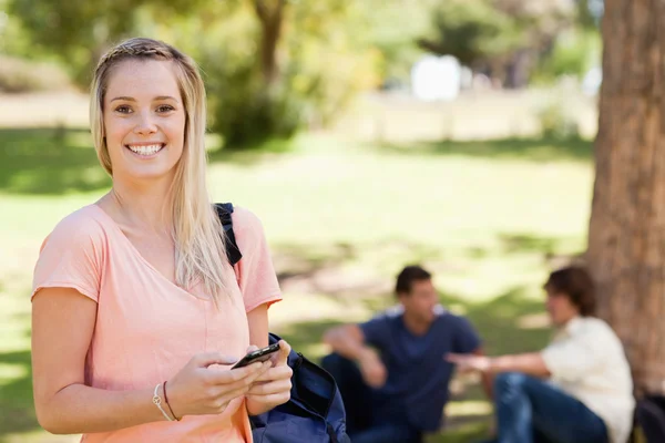 Retrato de una chica sonriente usando un smartphone —  Fotos de Stock