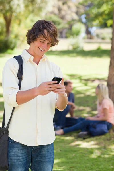 Jeune homme utilisant un smartphone — Photo