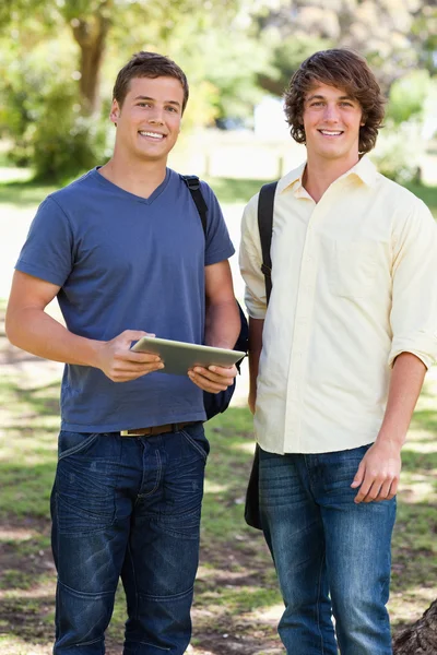 Porträtt av två leende manliga studenter med en touch pad — Stockfoto