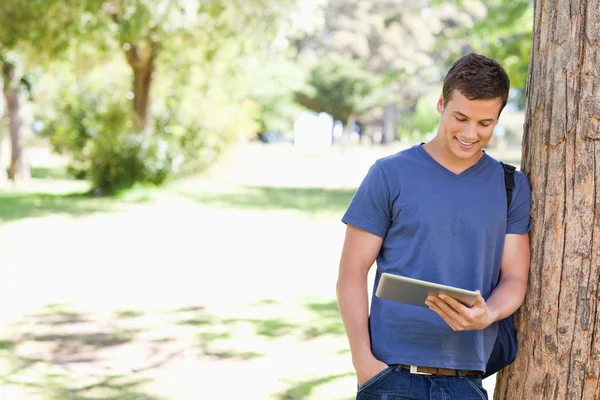 Étudiant appuyé contre un arbre — Photo