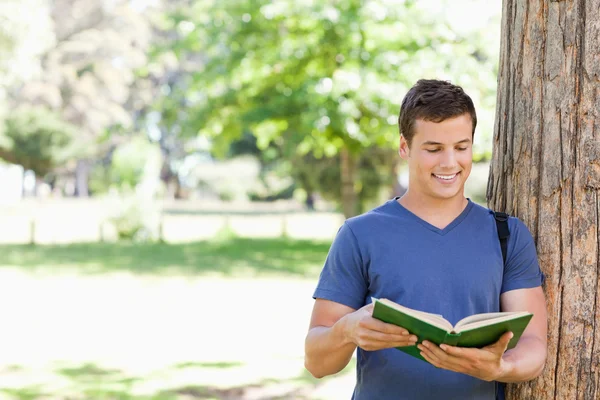 Muscled student holding a textbook — Stock Photo, Image
