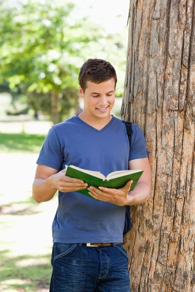 筋肉の若い男が本を読んで — ストック写真